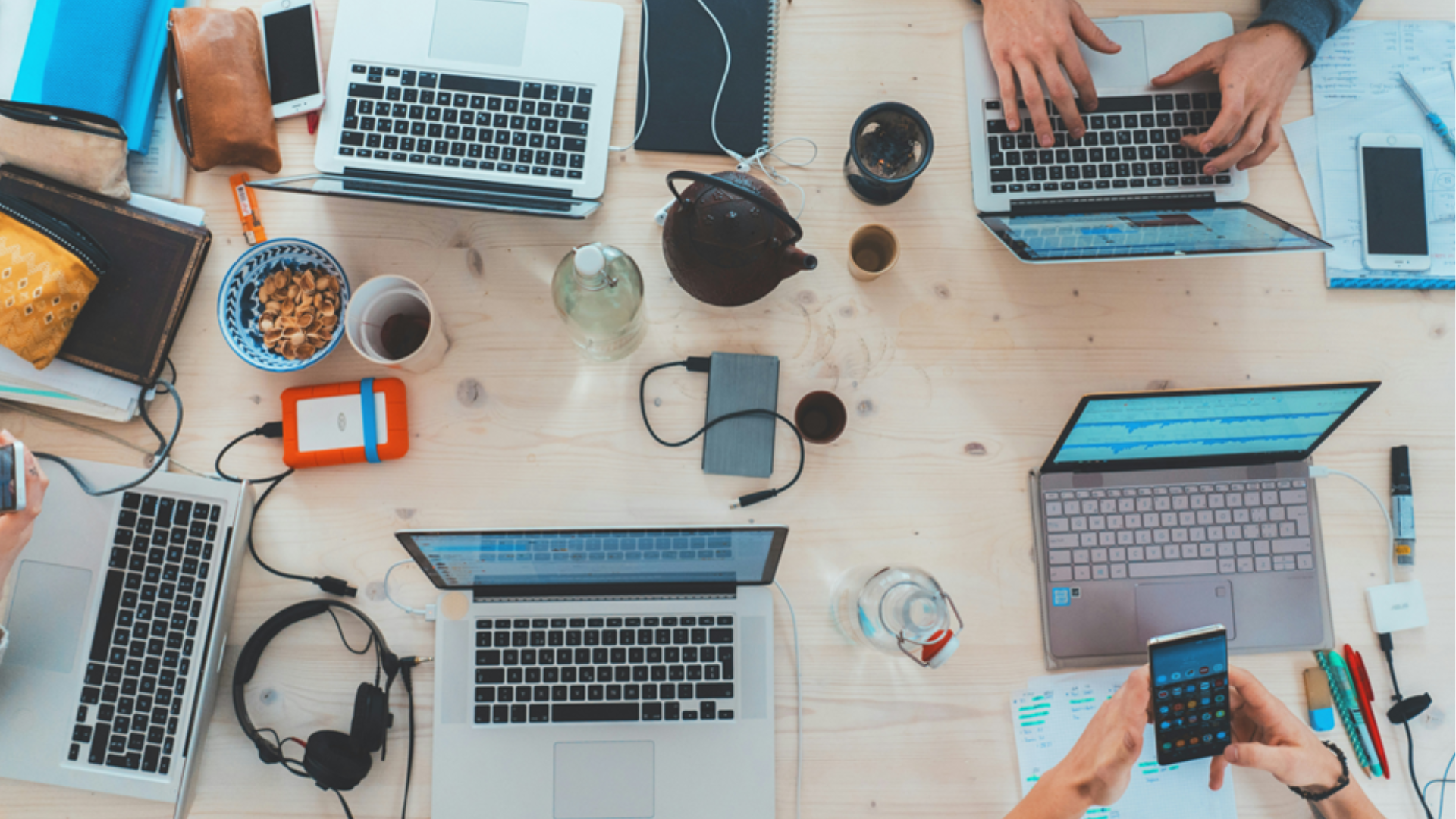 people sitting around a table with tech on it