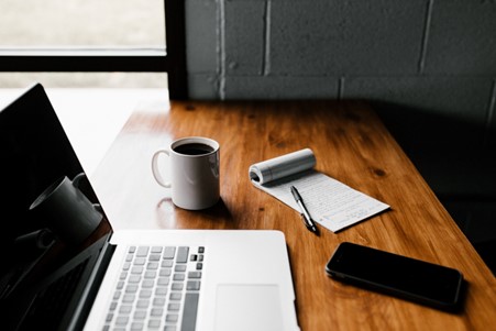 laptop witha cup of coffee and note pad