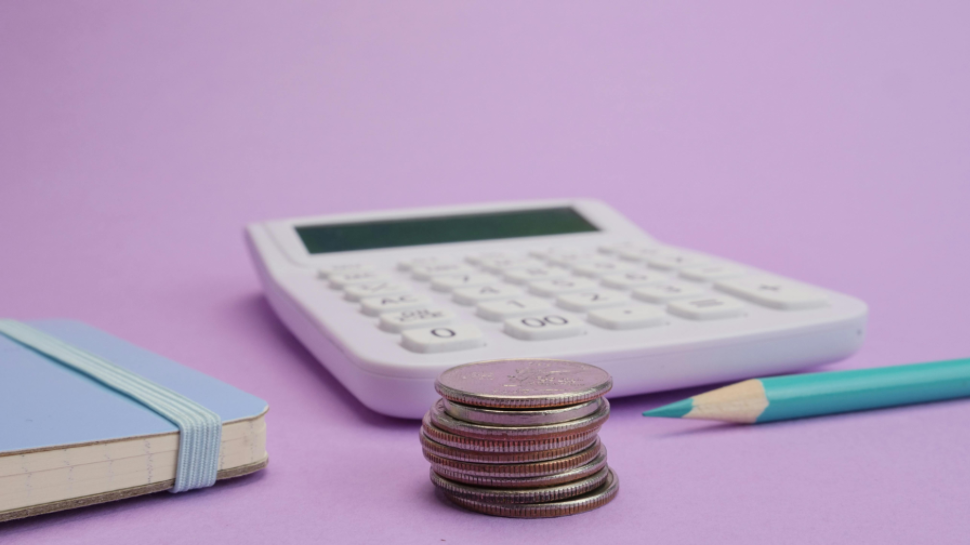 calculator with coins in front of it