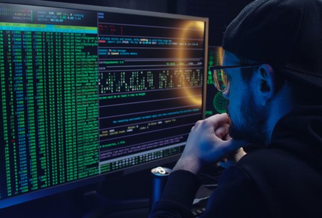 man looking at screen with code